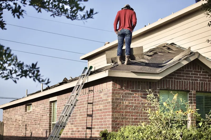 Professional roofer working on a residential roof in Salford Pond